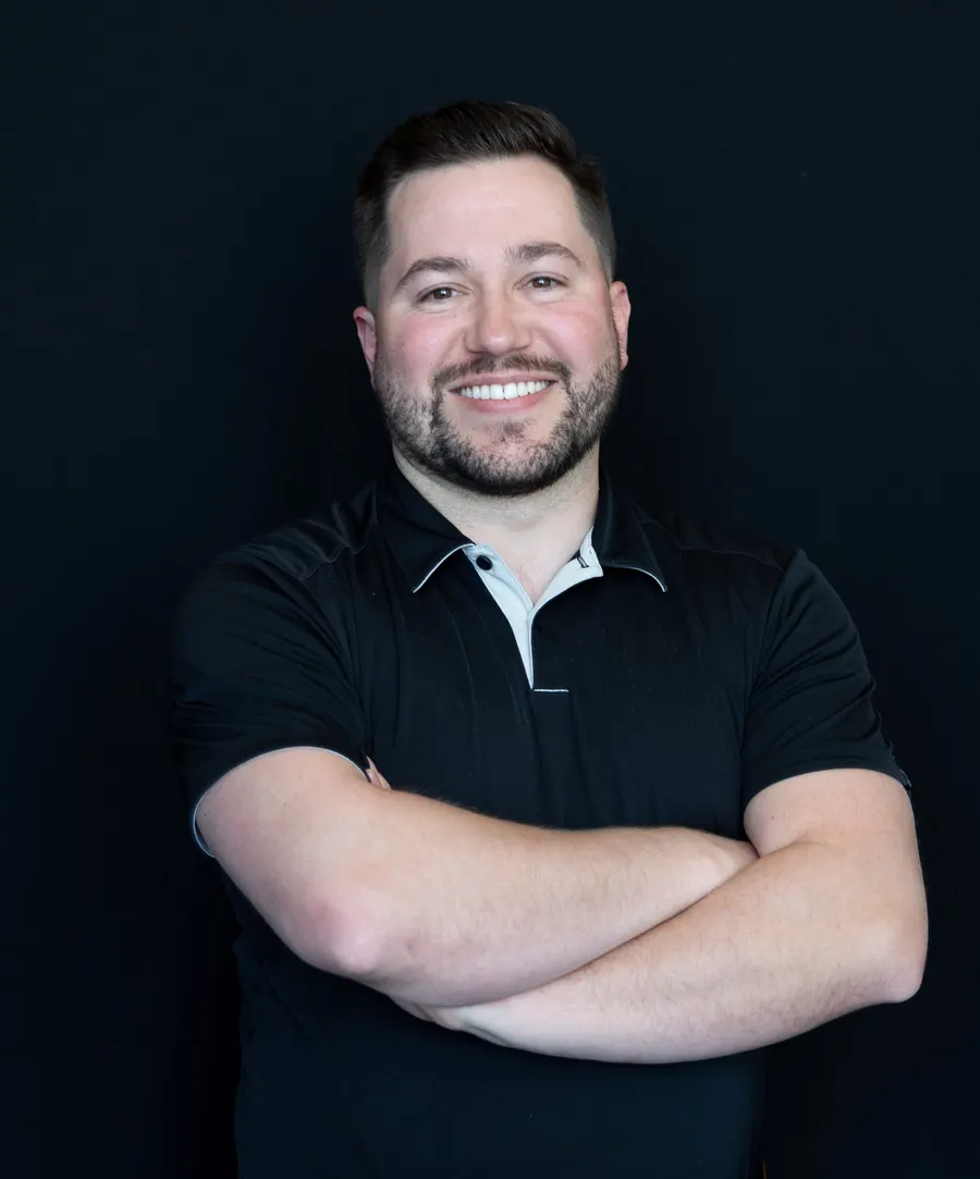 Dr. Zac Gallup, dentist at Highland Dental, smiling with arms crossed